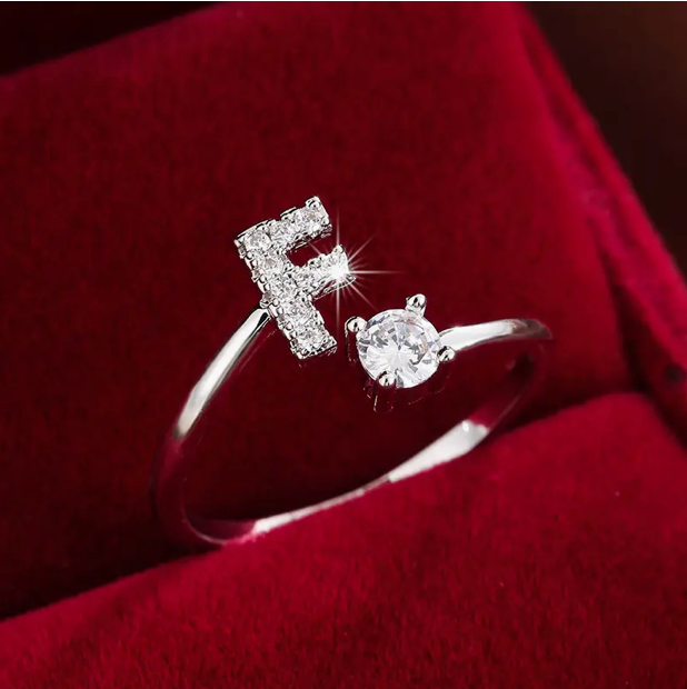 Faszinierender Buchstabenring aus Gold und Silber, besetzt mit funkelnden Diamanten